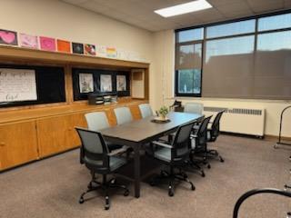 A meeting table with several chairs